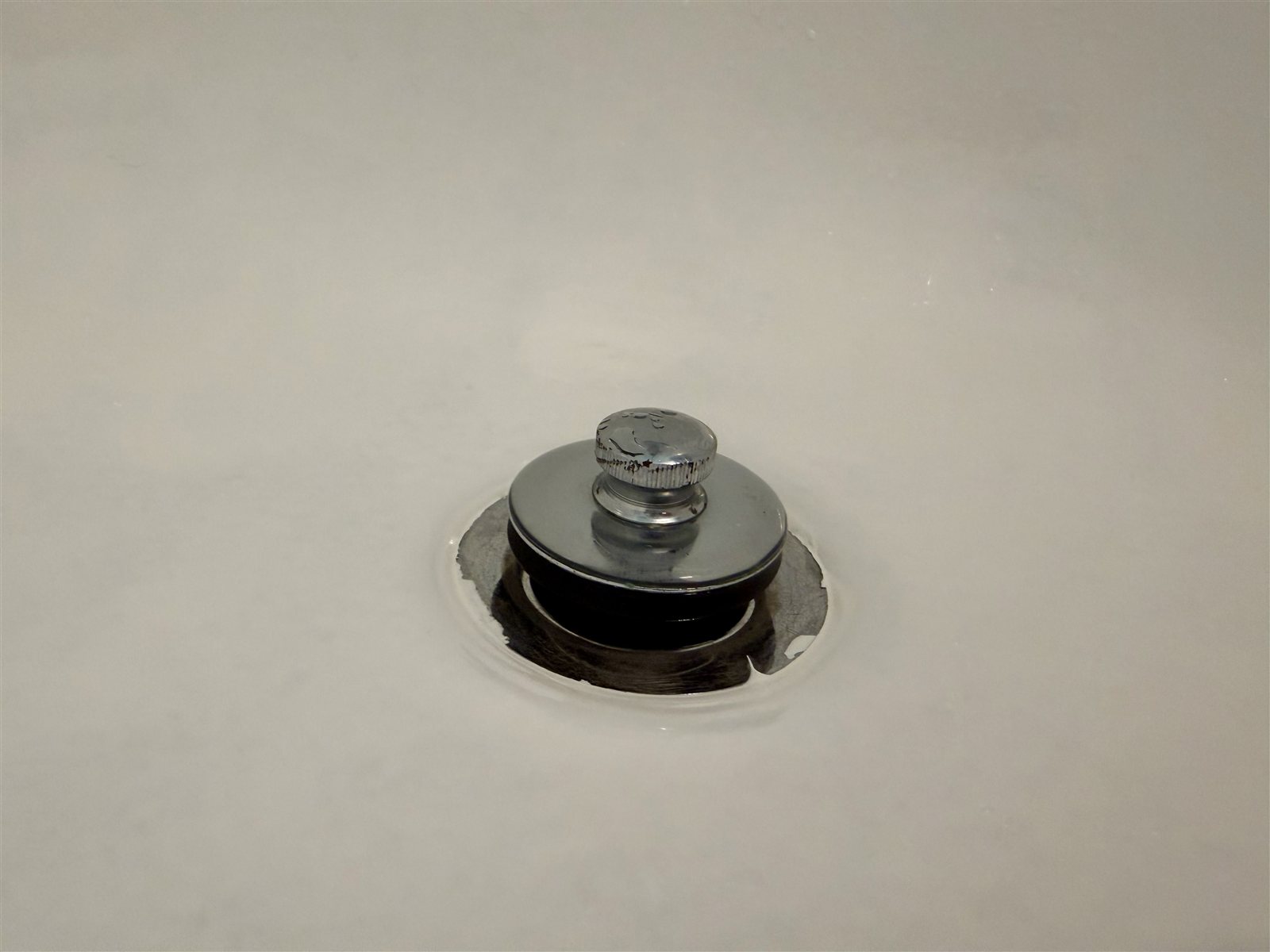 Paint wicked under the drain tape and dried on the chrome edges — result of not being able to remove the drain cover