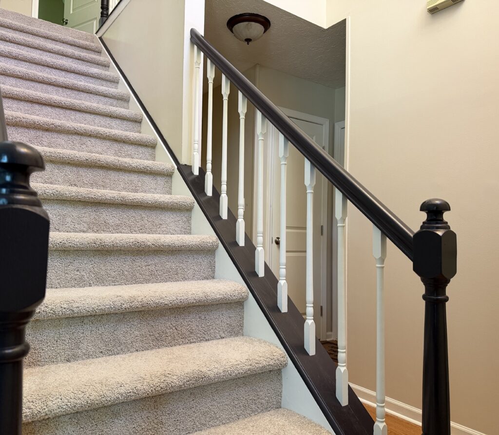 Painted white stair spindles and dark wood railing in a home interior